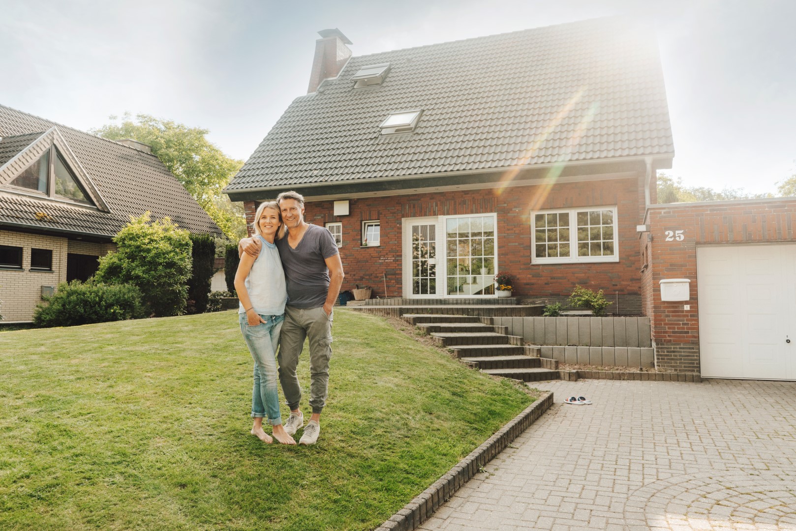 Smiling mature couple embracing in garden of their home